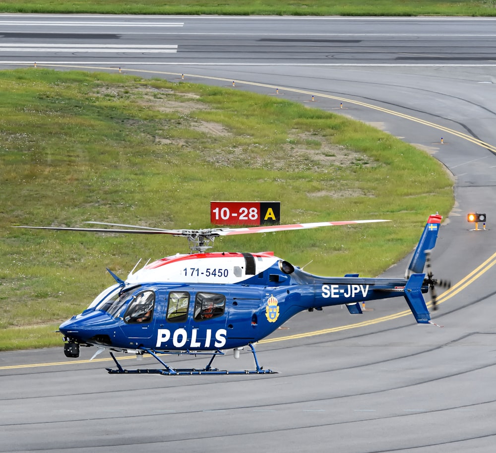 a police helicopter taking off from an airport runway
