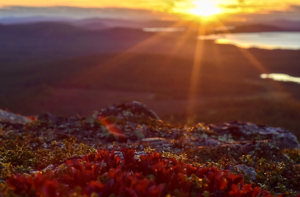 the sun is setting over the mountains and water