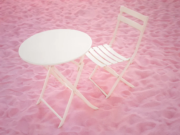 A sturdy white foldable table set up outdoors in Riyadh with a backdrop of modern buildings.