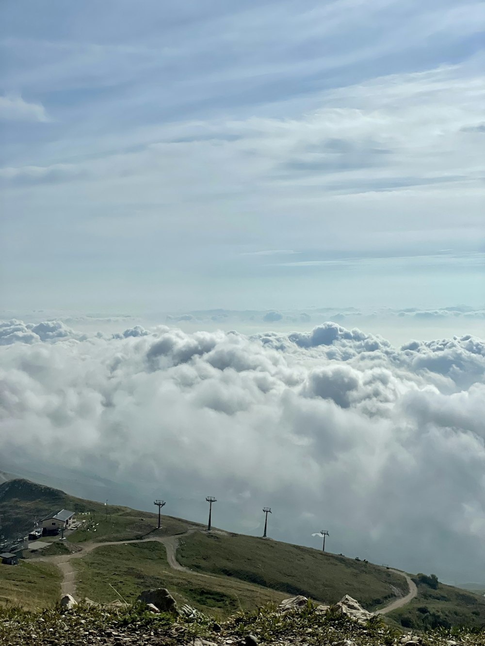 una colina cubierta de nubes y árboles en la cima de una colina