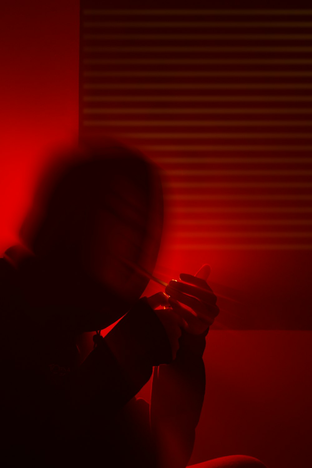 a person sitting in a dark room with a red light
