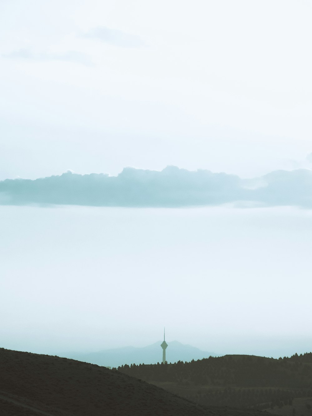 a view of a hill with a tower in the distance