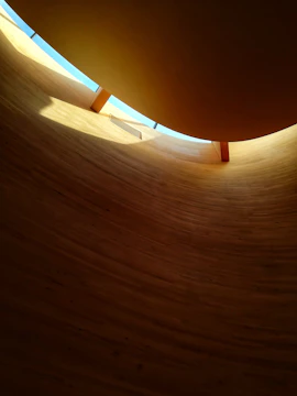 A custom wooden structure framing a cozy living space with natural textures and soft gold accents.