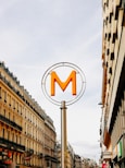 a street sign with the letter m on top of it