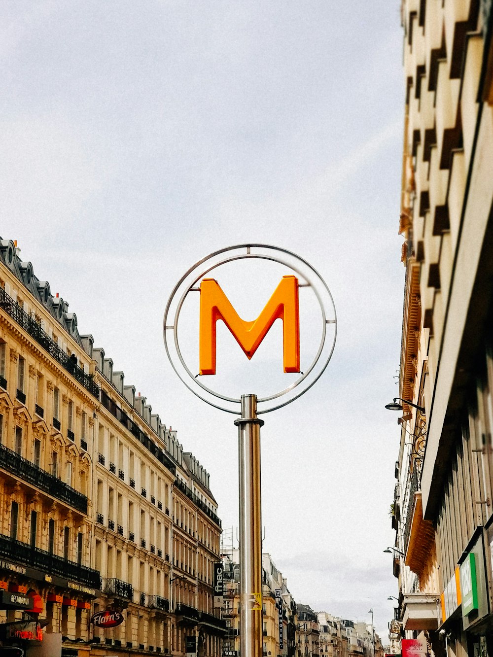 a street sign with the letter m on top of it