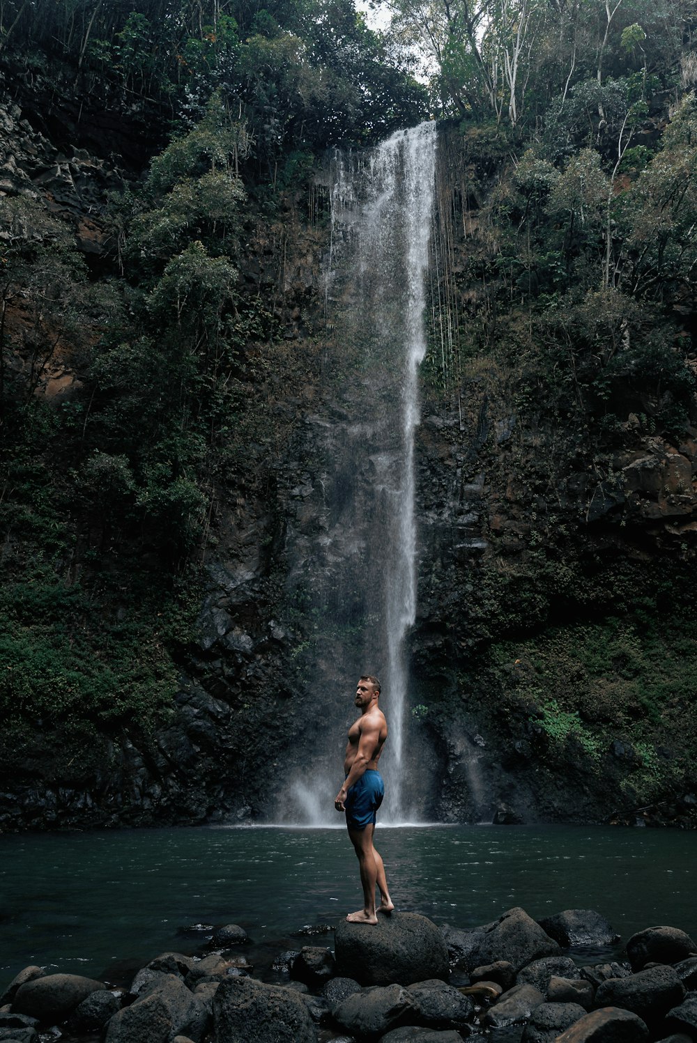 a man standing in front of a waterfall