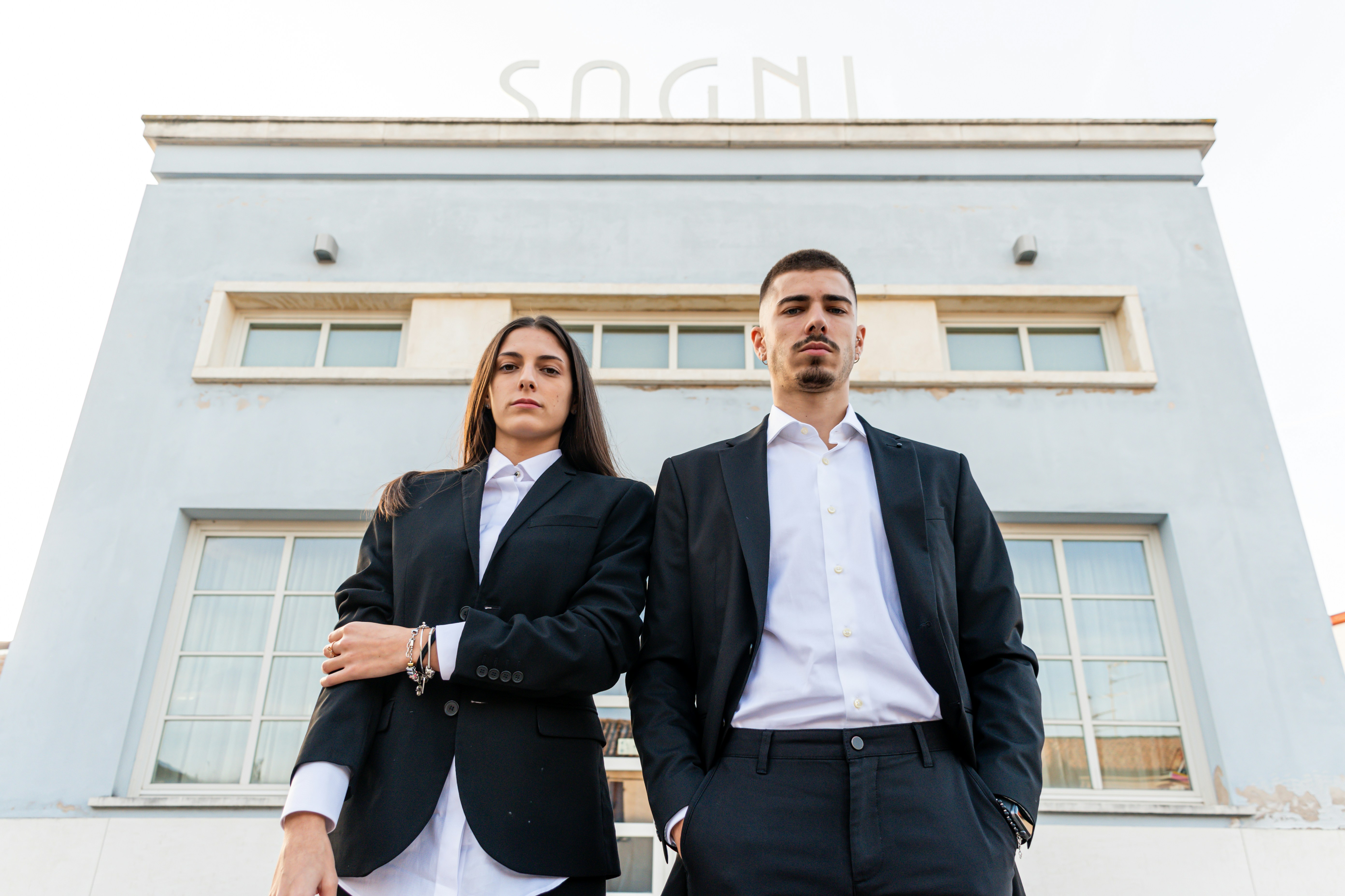 a man and a woman standing in front of a building