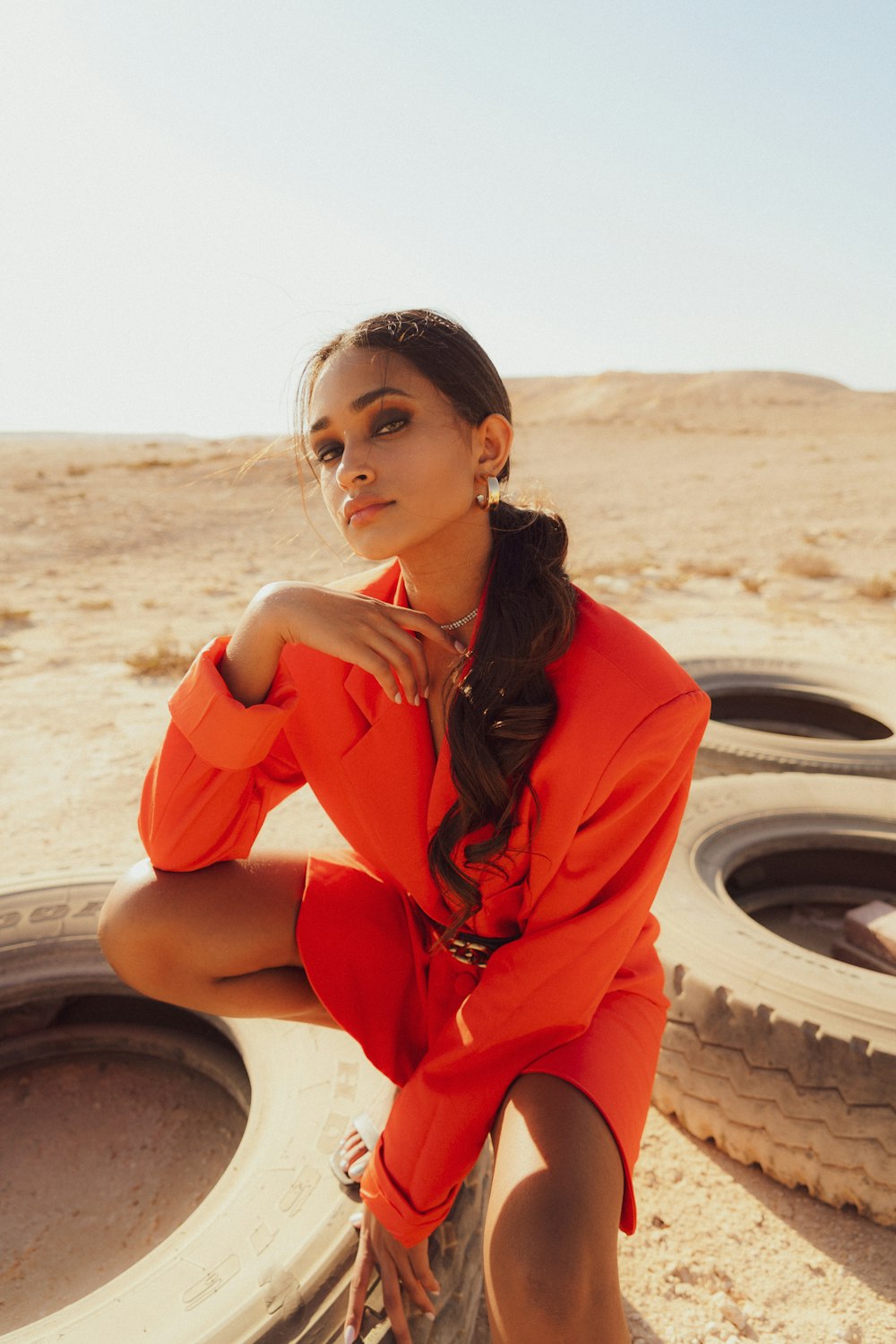 a woman sitting on a tire in the desert