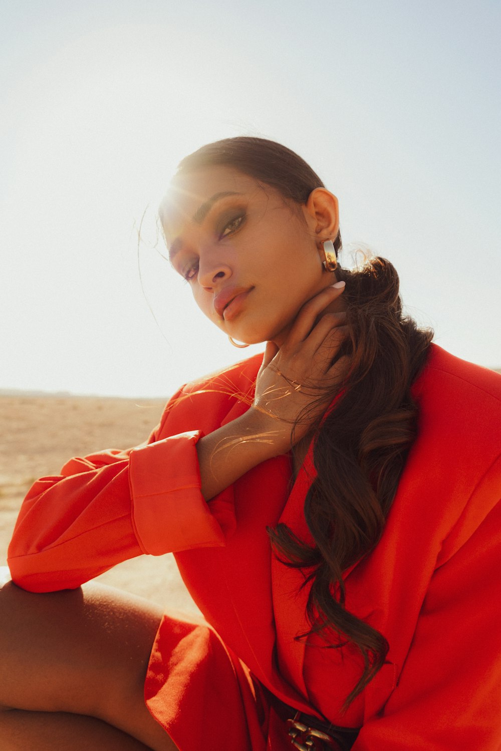 a woman in a red suit sitting on a beach