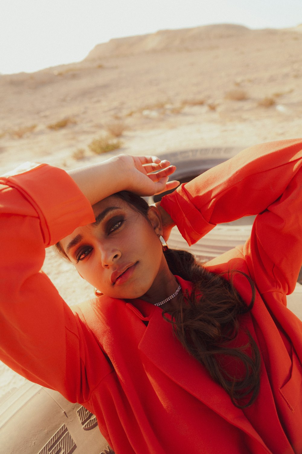 a woman in an orange top posing for a picture