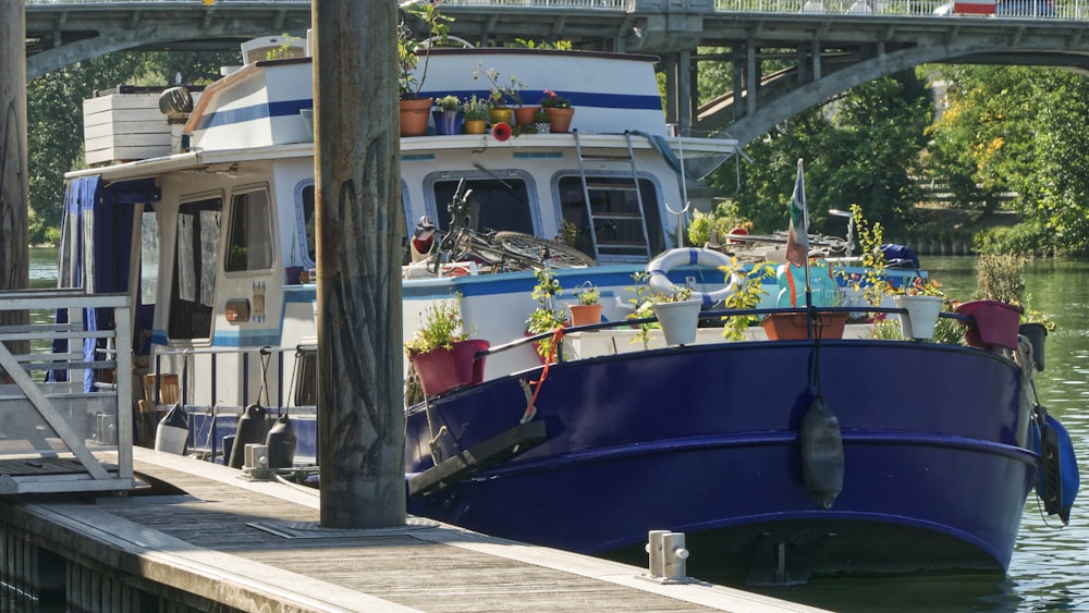 a blue and white boat docked at a pier