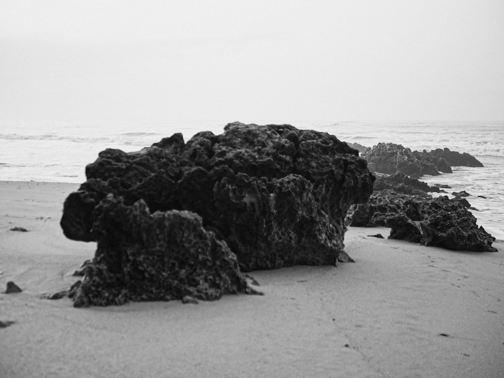a black and white photo of rocks on the beach