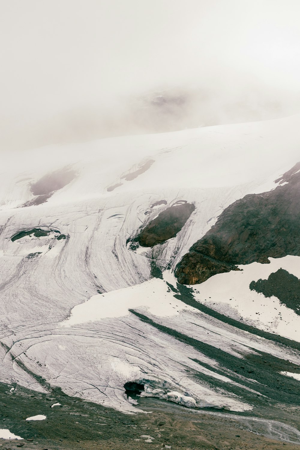 Une montagne couverte de neige avec quelques nuages dans le ciel