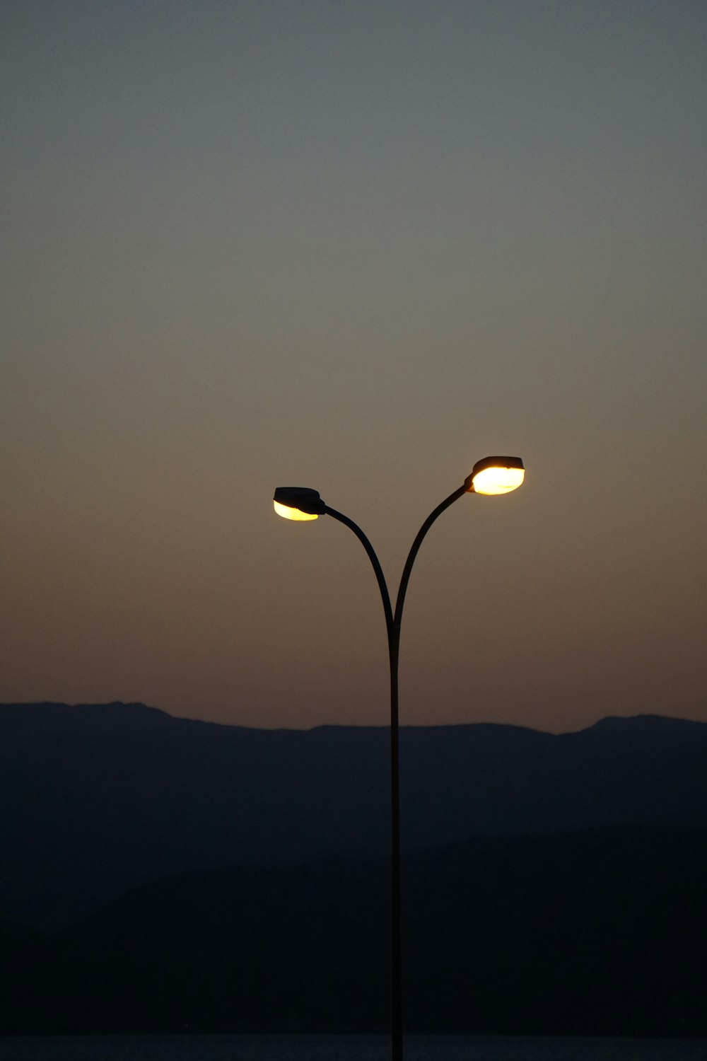 a street light with a sunset in the background