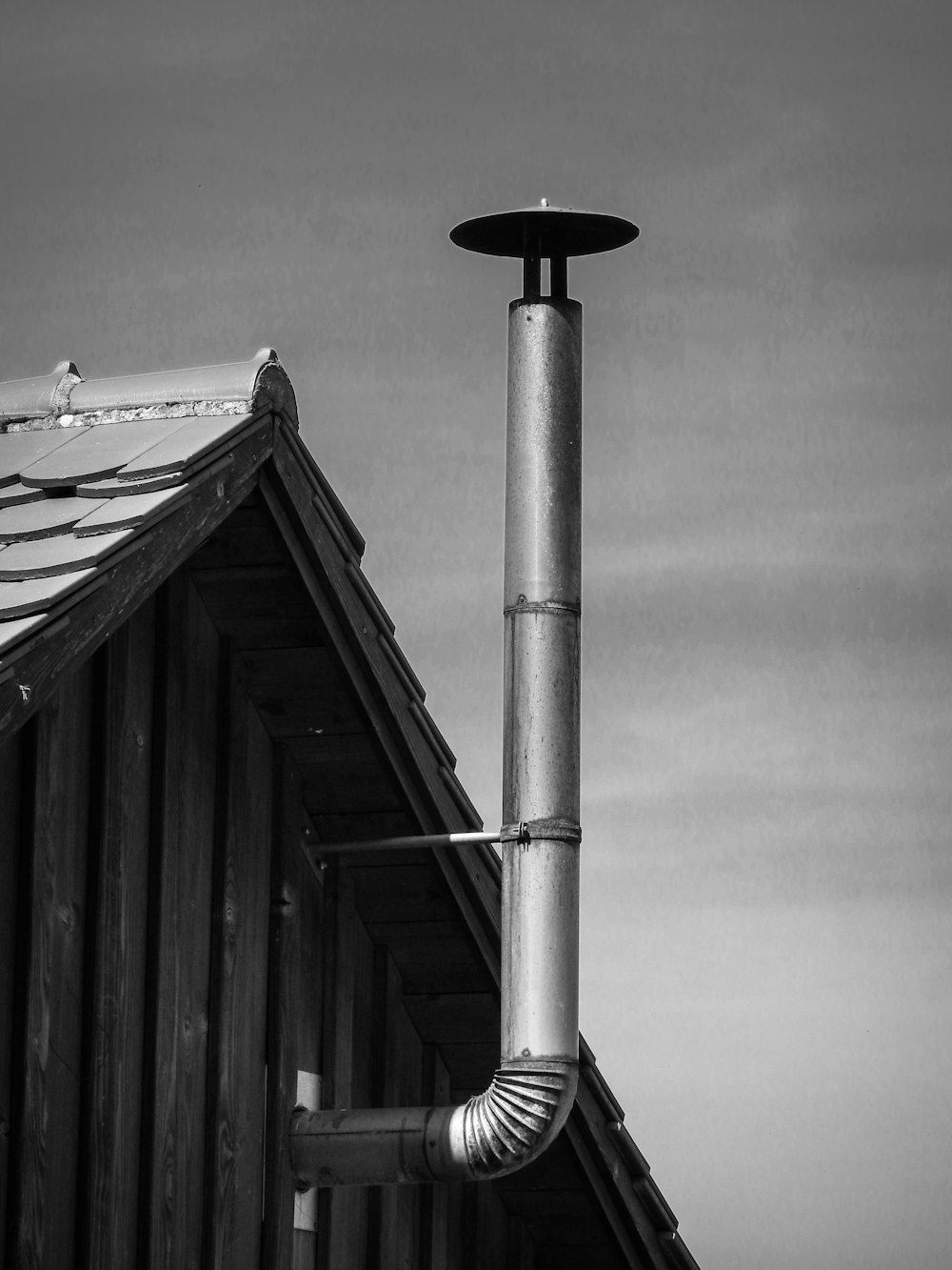 a black and white photo of a pipe on a roof