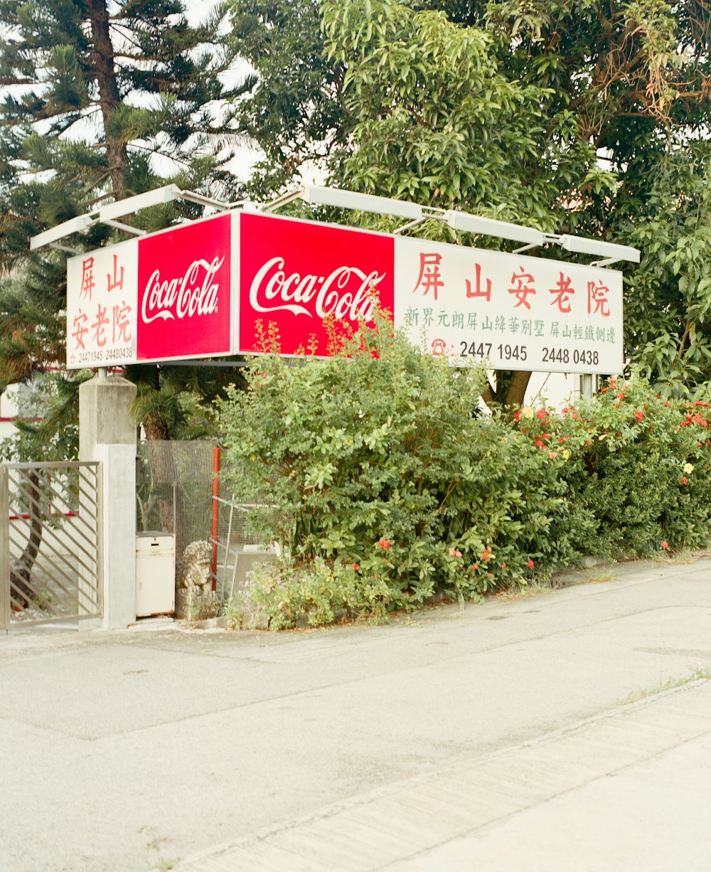 a coca - cola sign on the side of a road