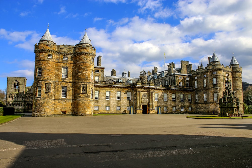 a large castle like building sitting on top of a lush green field