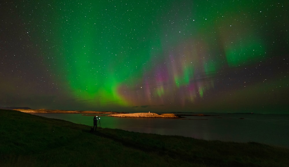 a person standing on a hill looking at the sky