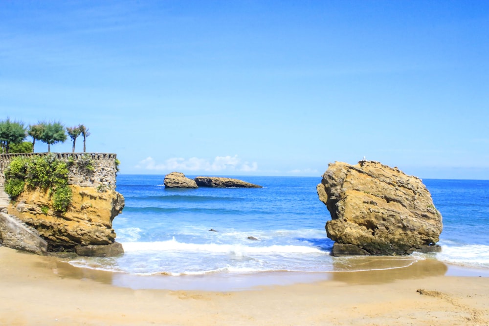 a couple of large rocks sitting on top of a beach