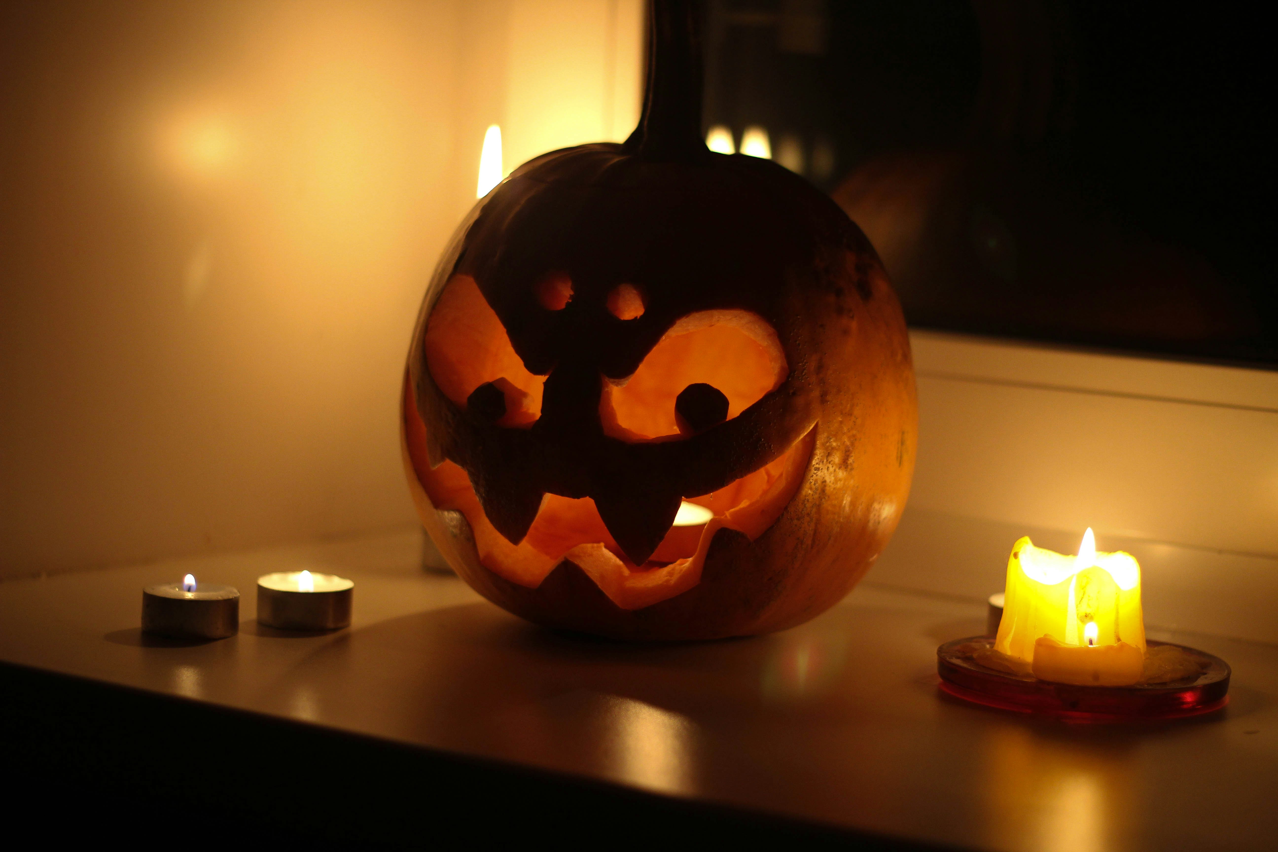 A carved pumpkin sitting on top of a table next to candles