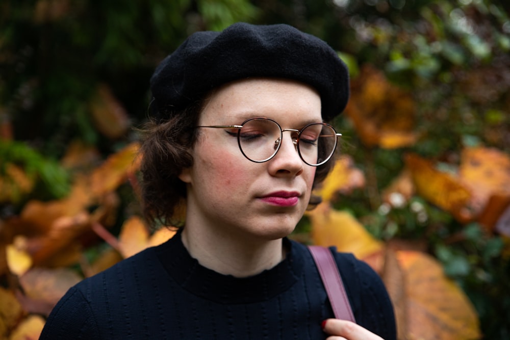 a woman wearing glasses and a black hat