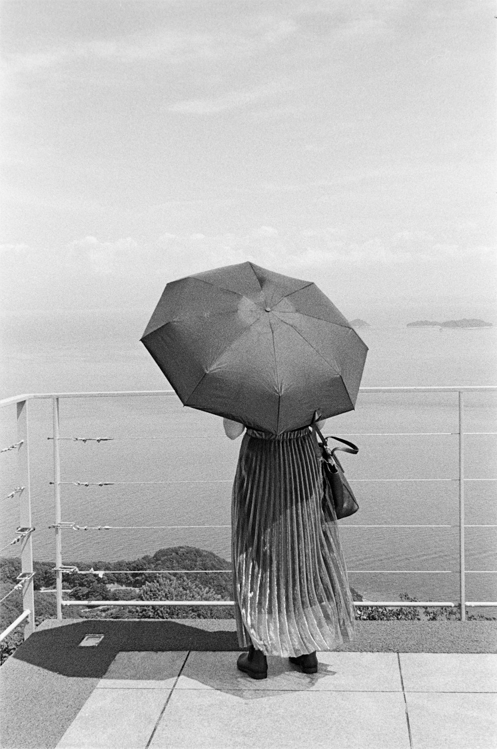 a woman holding an umbrella on top of a roof