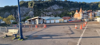 A beginner driver practicing parking in an empty lot with cones and guidance.