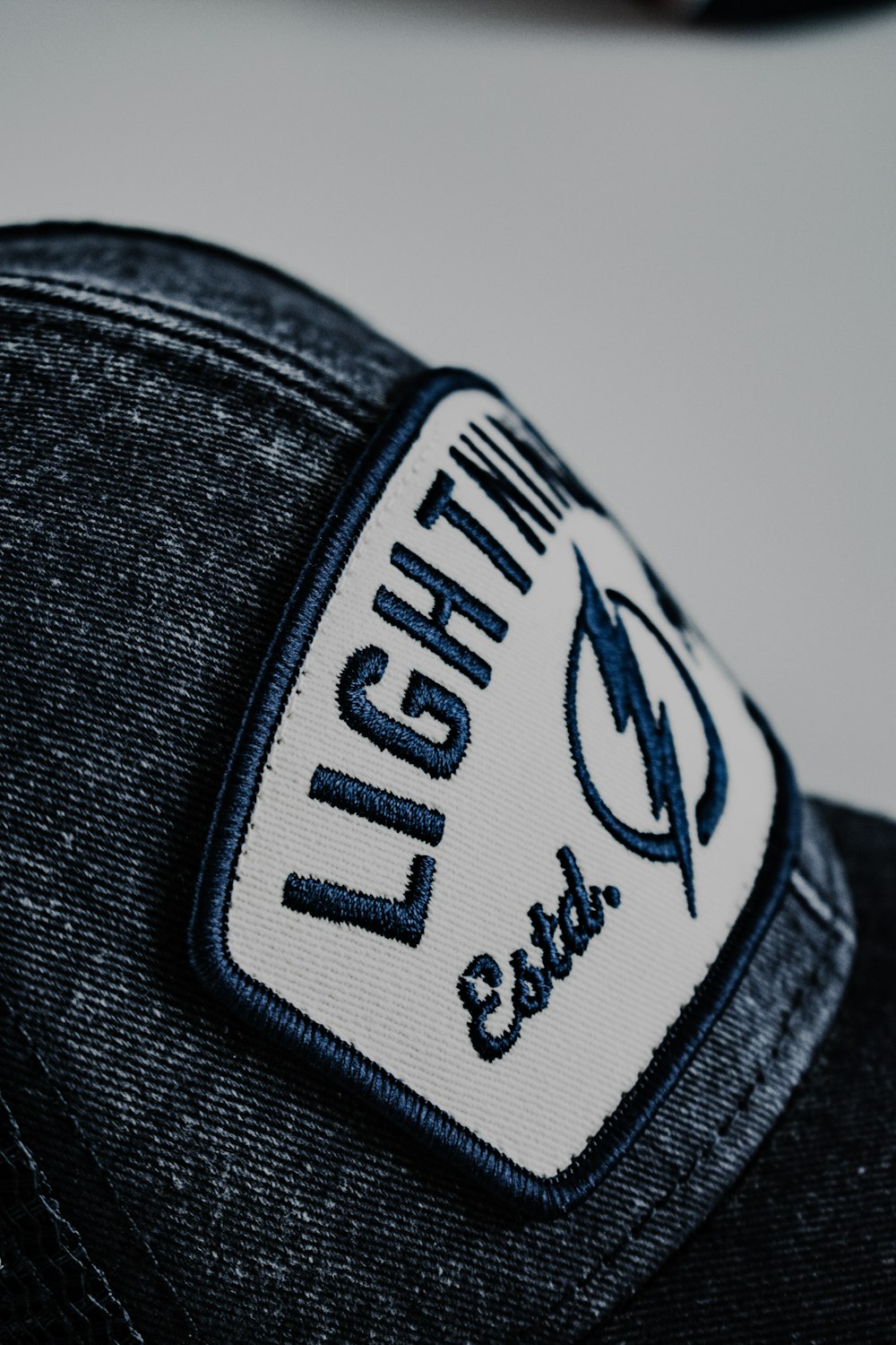 a close up of a hat with a lightning patch on it