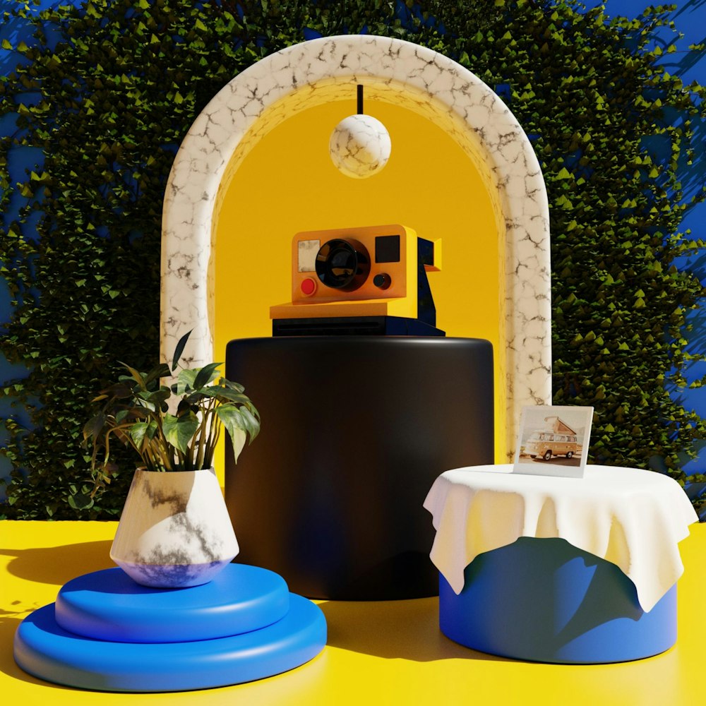 a yellow and blue table with a camera and a plant