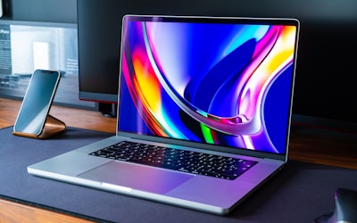 a laptop computer sitting on top of a wooden desk