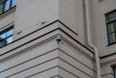 Close-up of a CCTV camera mounted on a building corner.