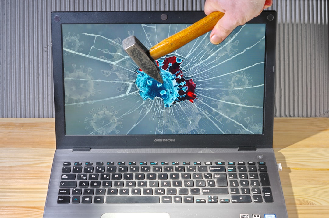 a person holding a pencil and a broken laptop,