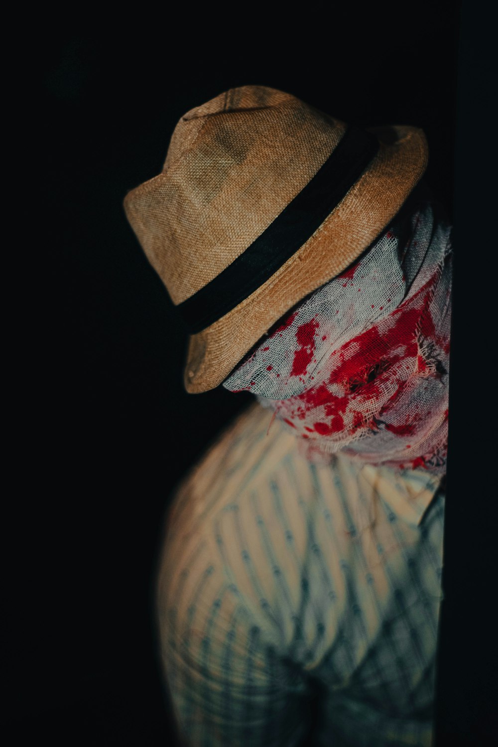 a person with a bloody face and a hat