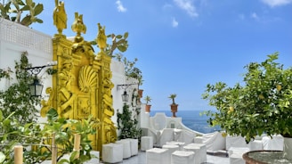 A cozy terracotta-toned terrace with lemon trees and sculpted plaster faces on the walls.