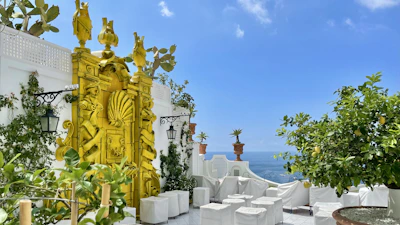 An elegant terrace overlooking Marbella’s luxury co-living spaces framed by lush greenery and ocean views.