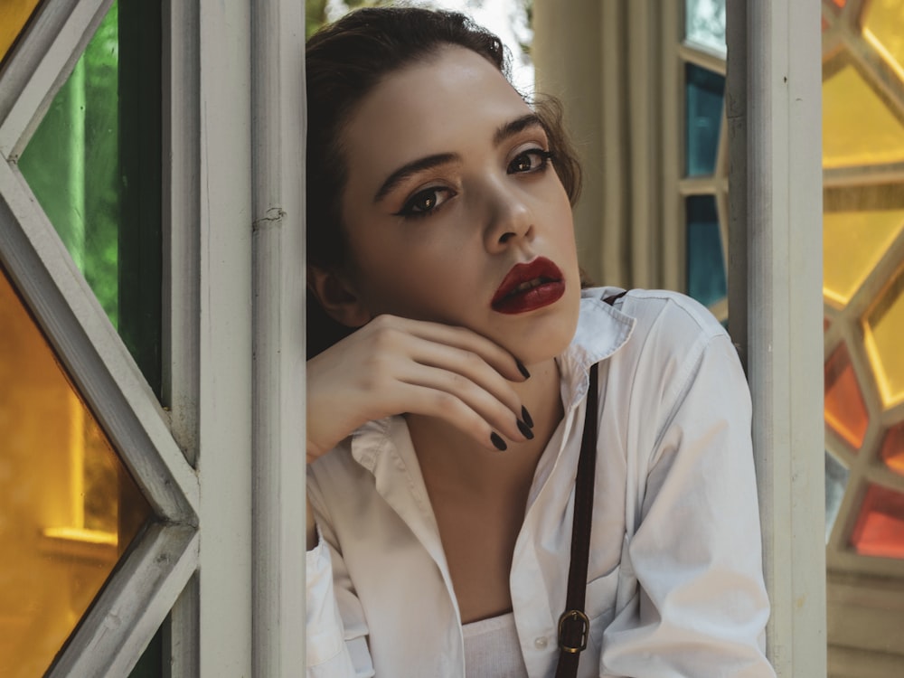 a woman wearing a white shirt and red lipstick