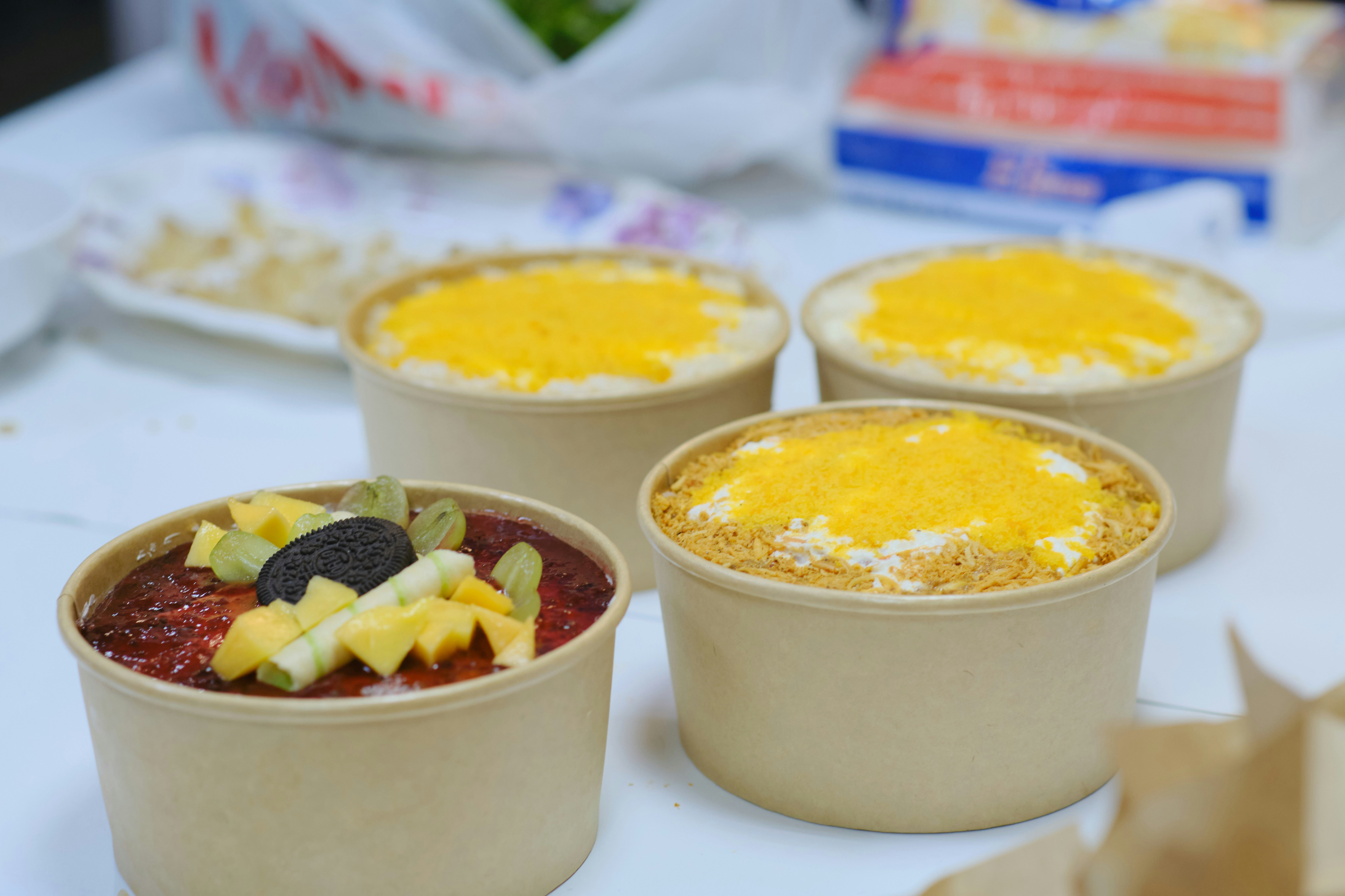 Paper cups of mango dessert on a table