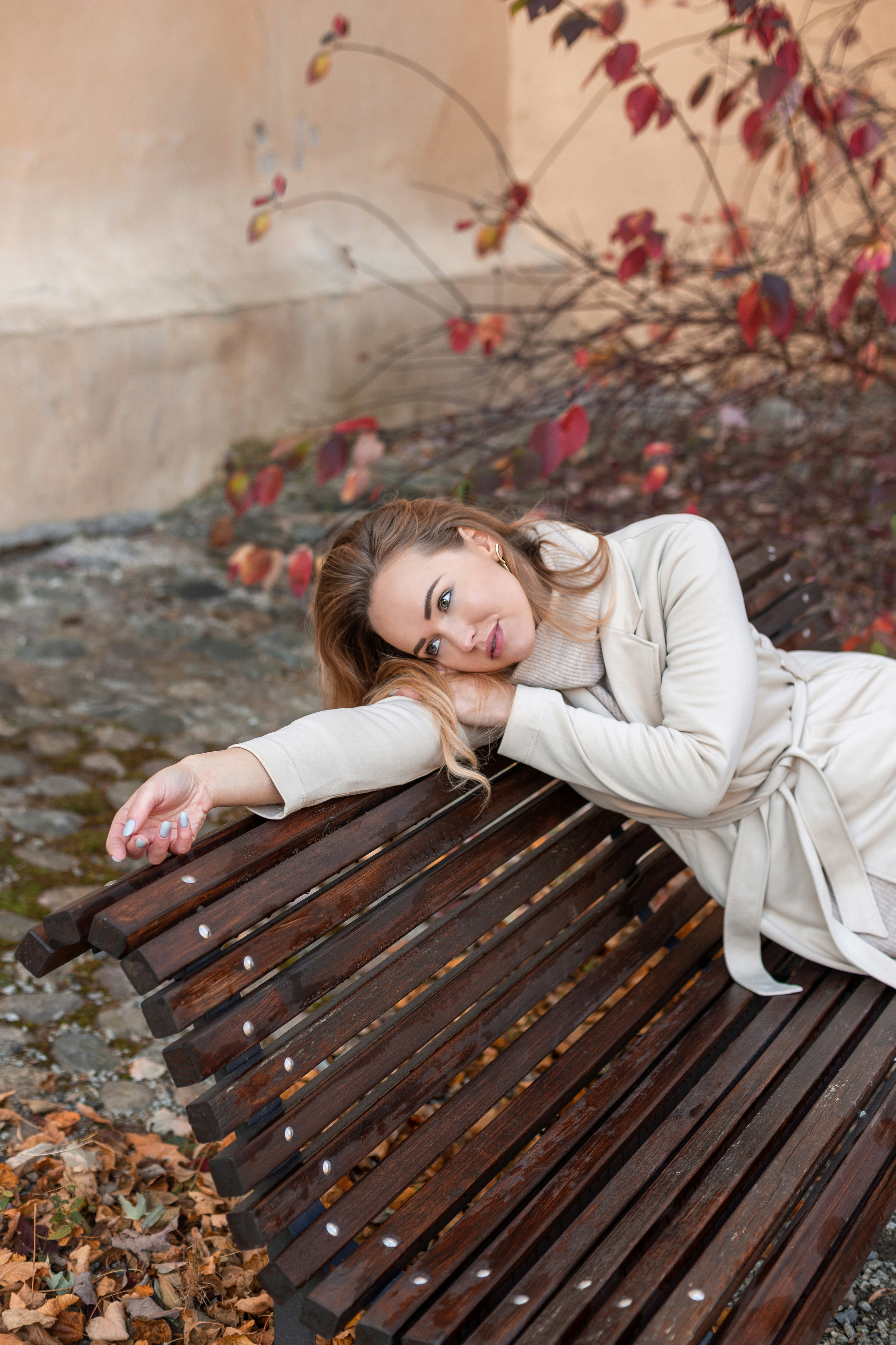 a woman sitting on top of a wooden bench