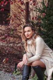 a woman sitting on top of a wooden bench