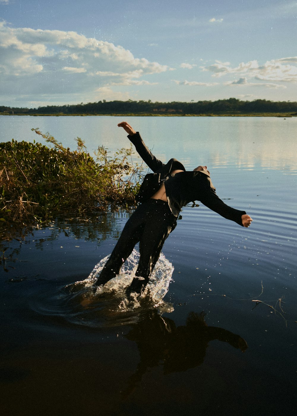 ウェットスーツを着た男が水しぶきを上げる