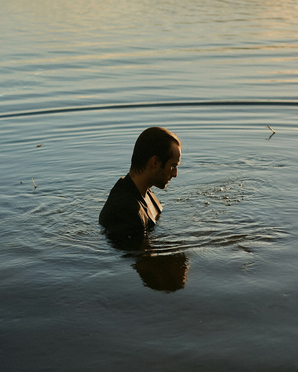 a man in a body of water with a frisbee