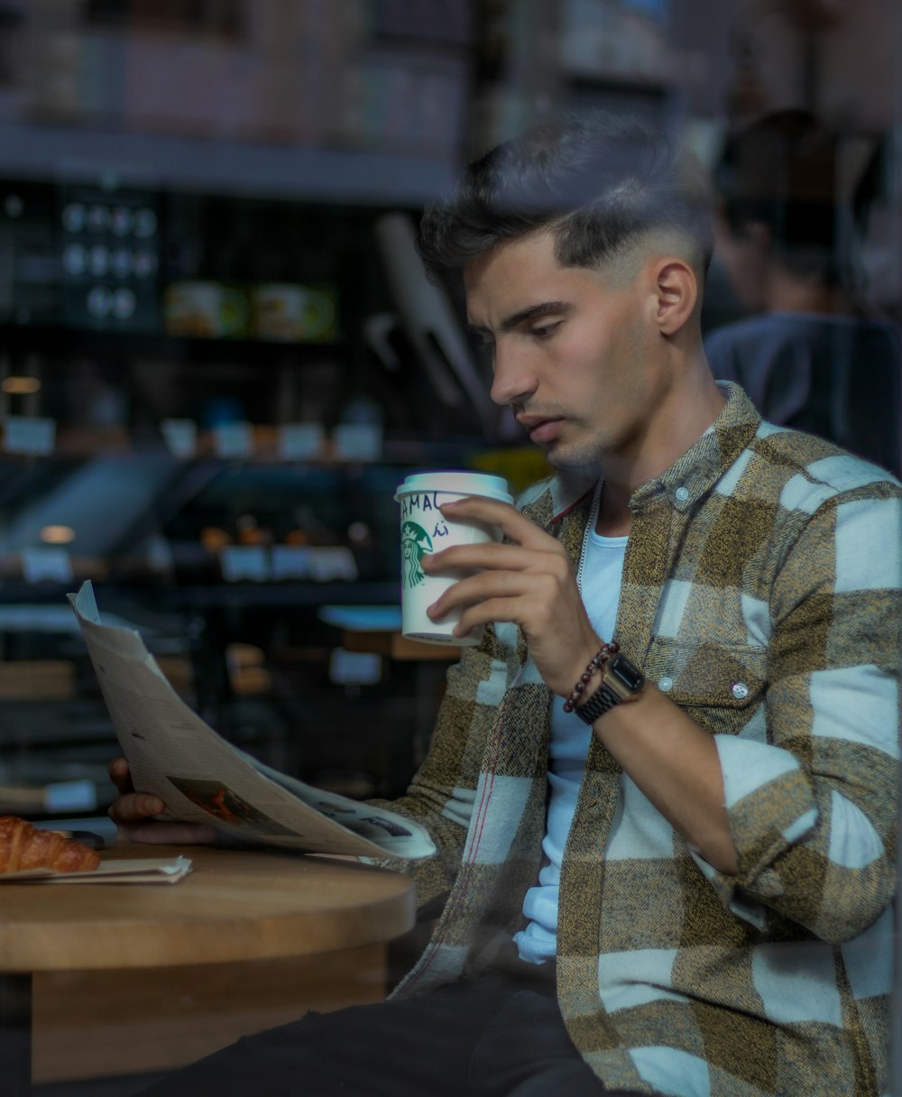 a man sitting at a table with a cup of coffee