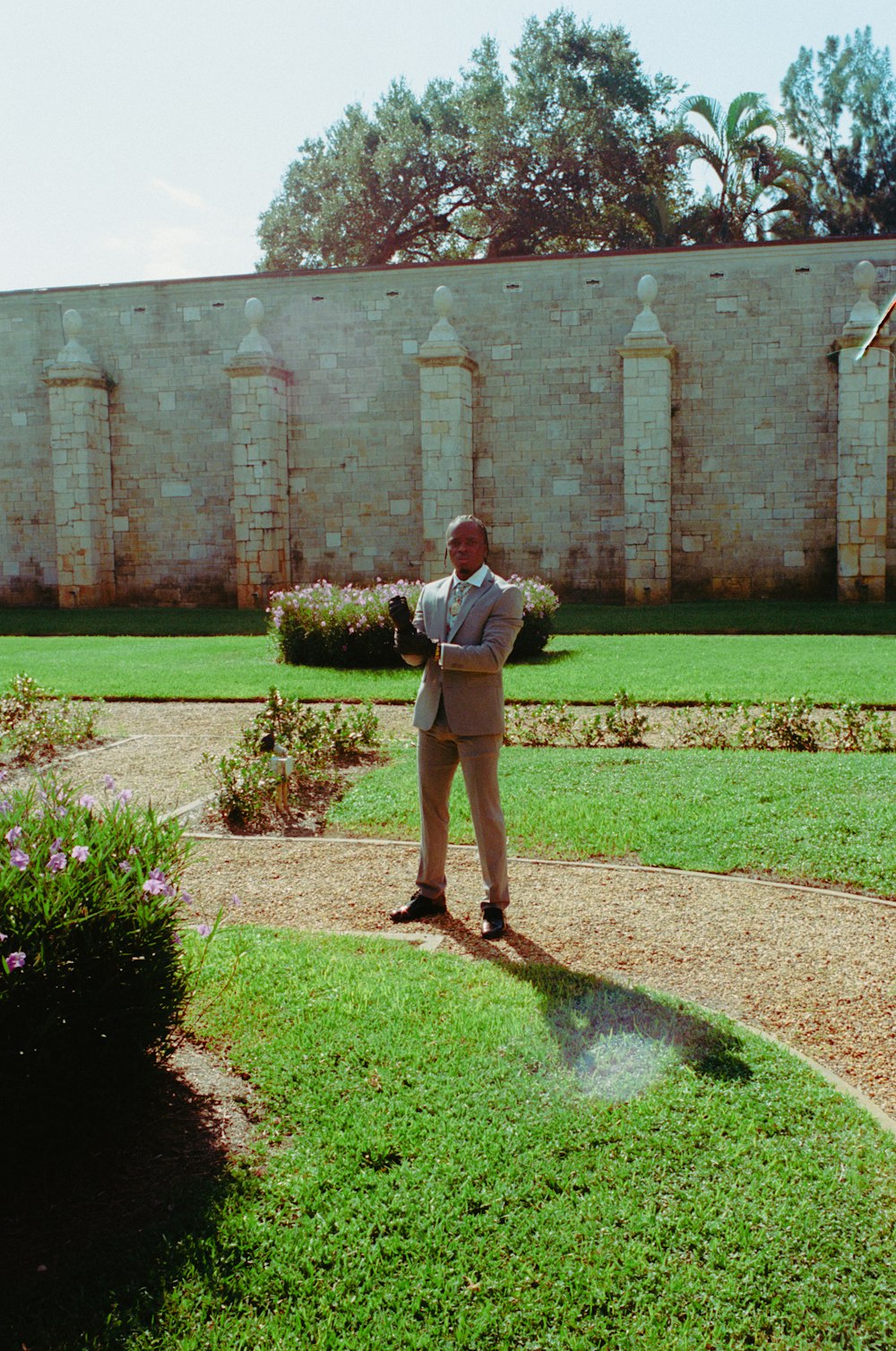 Un homme en costume debout dans un jardin