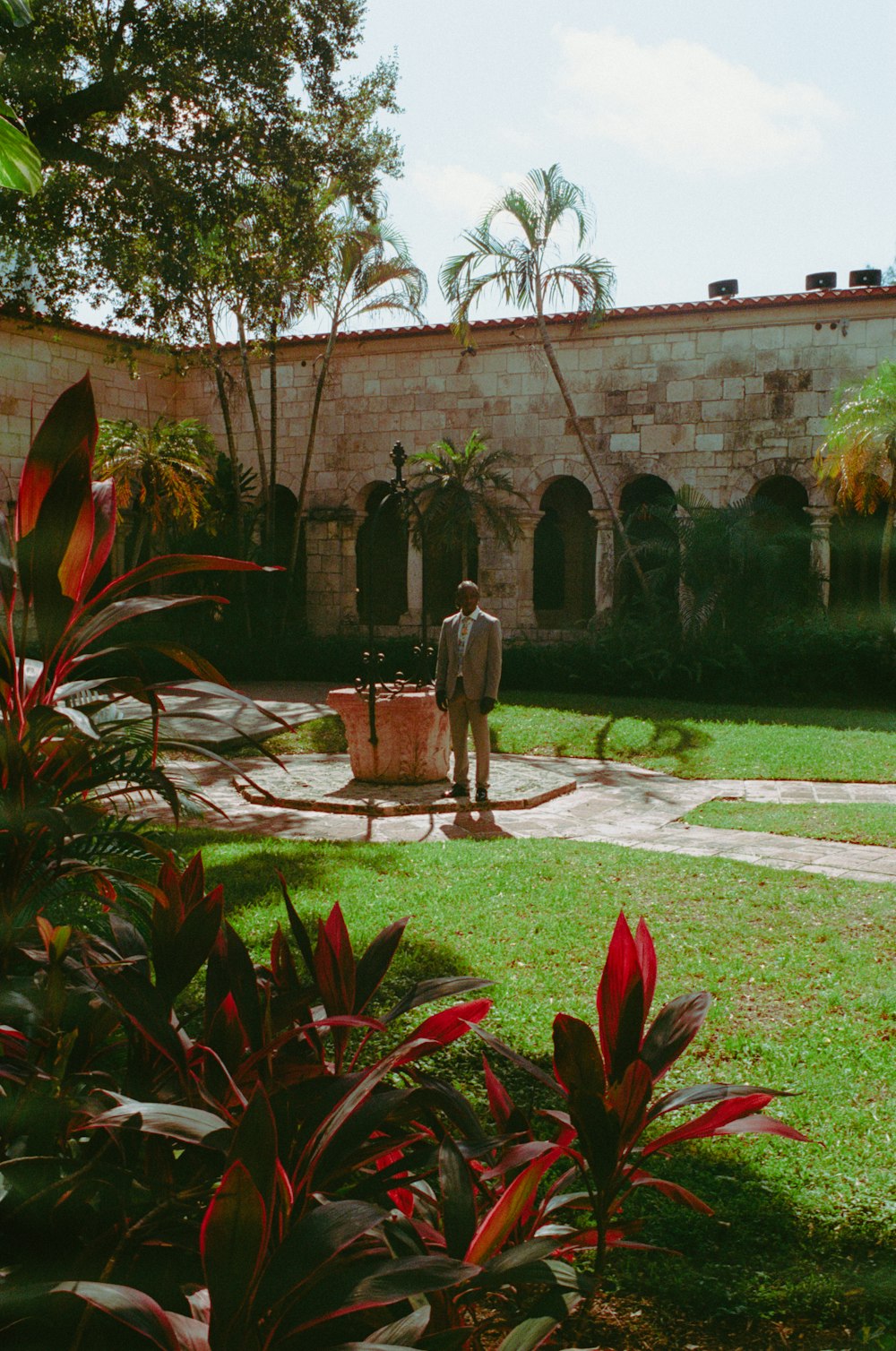 a man standing in a yard with a suitcase