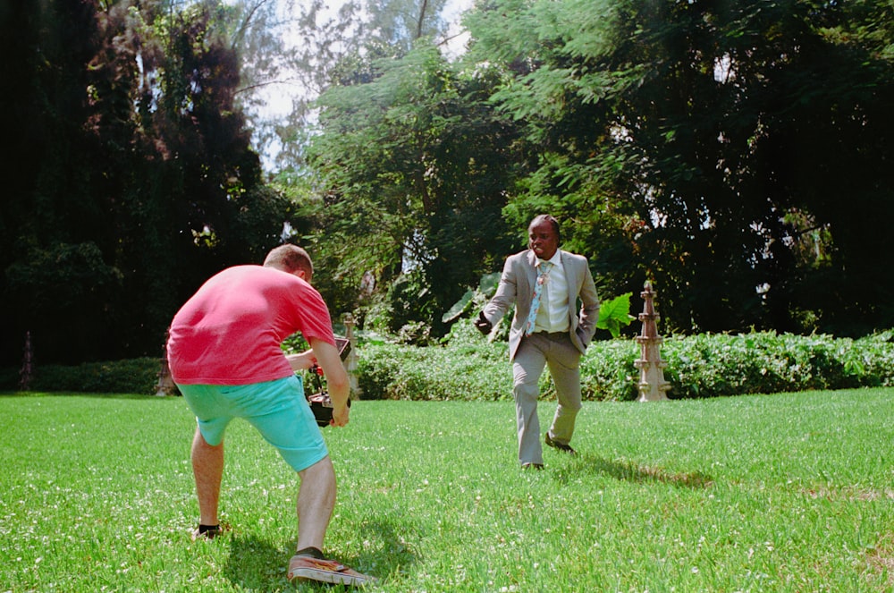 two men playing a game of frisbee in the grass