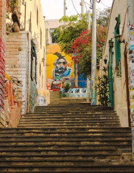a set of stairs leading up to a graffiti covered building