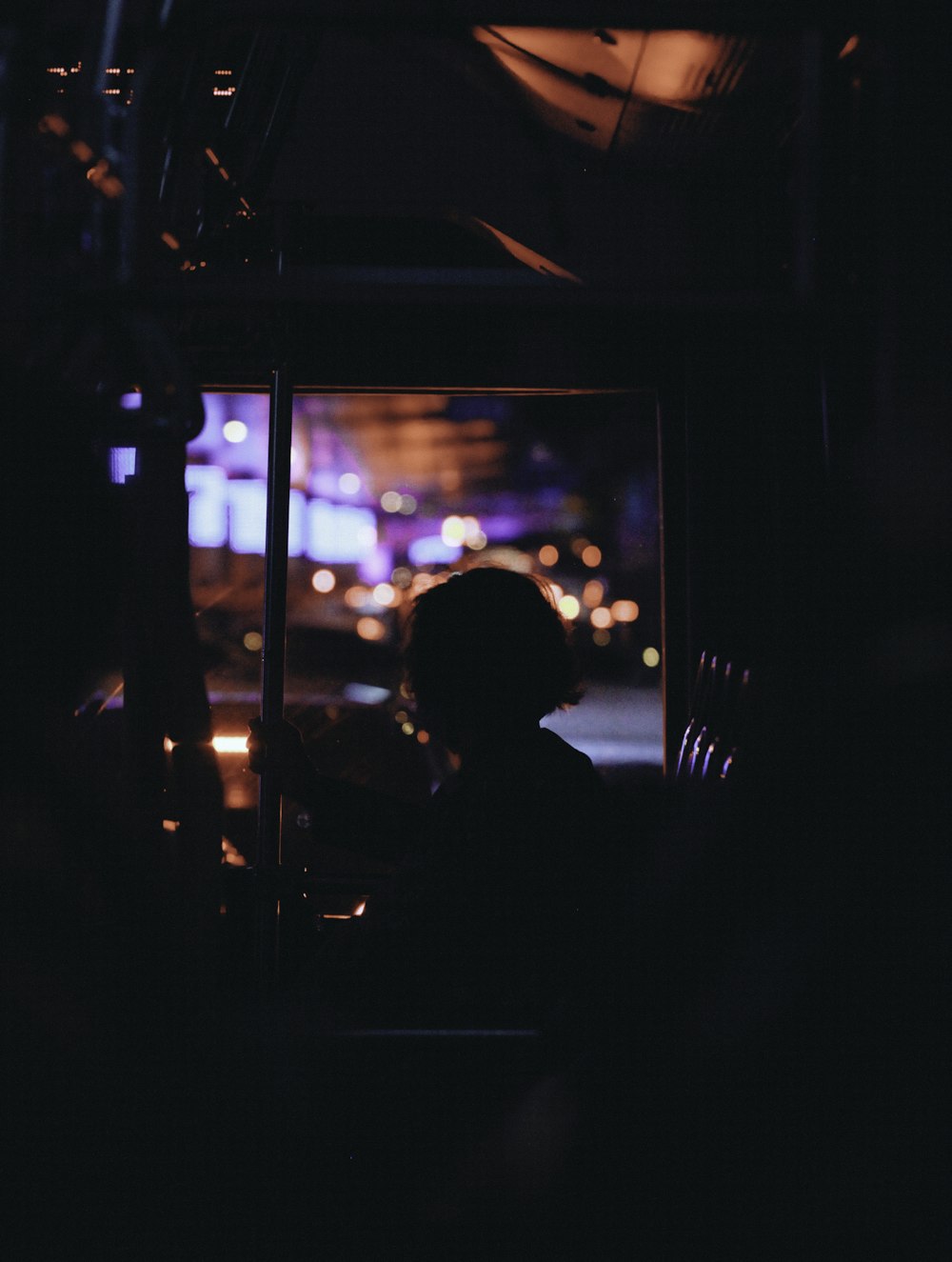 a person sitting in a bus at night