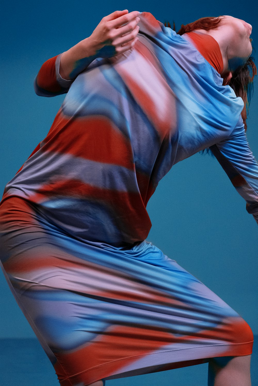 a woman in a colorful dress holding a tennis racquet