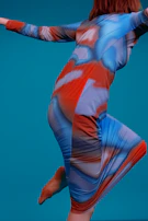 Close-up of a flowing dress blending classic corporate cuts with colorful tie-dye fabric textures.