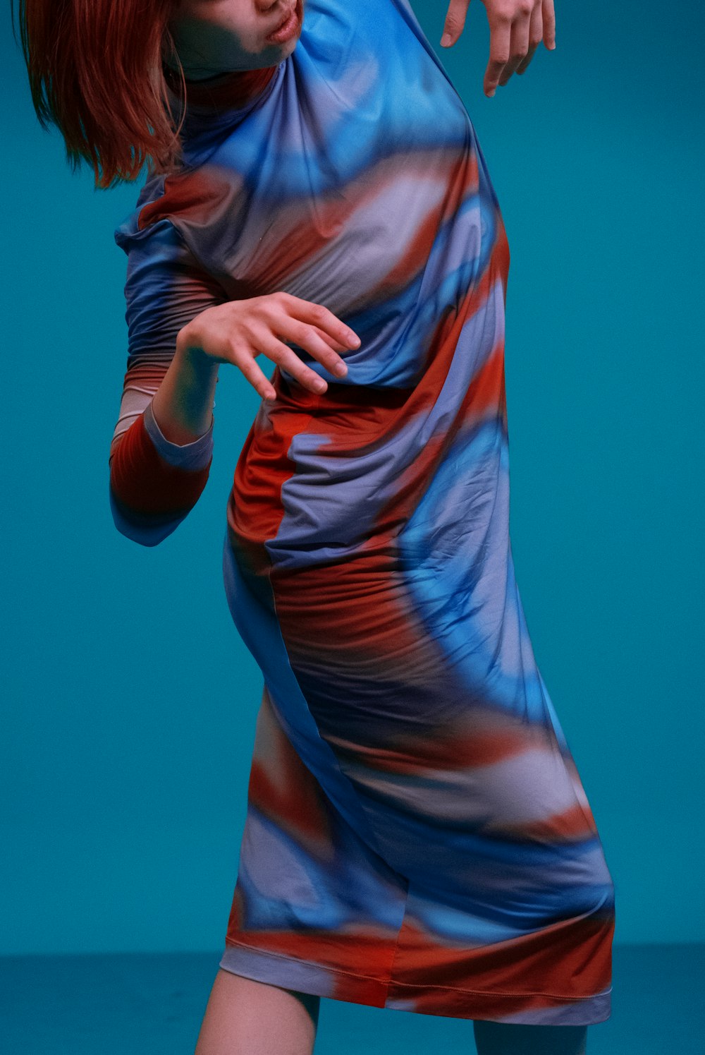 a woman in a colorful dress holding a tennis racquet